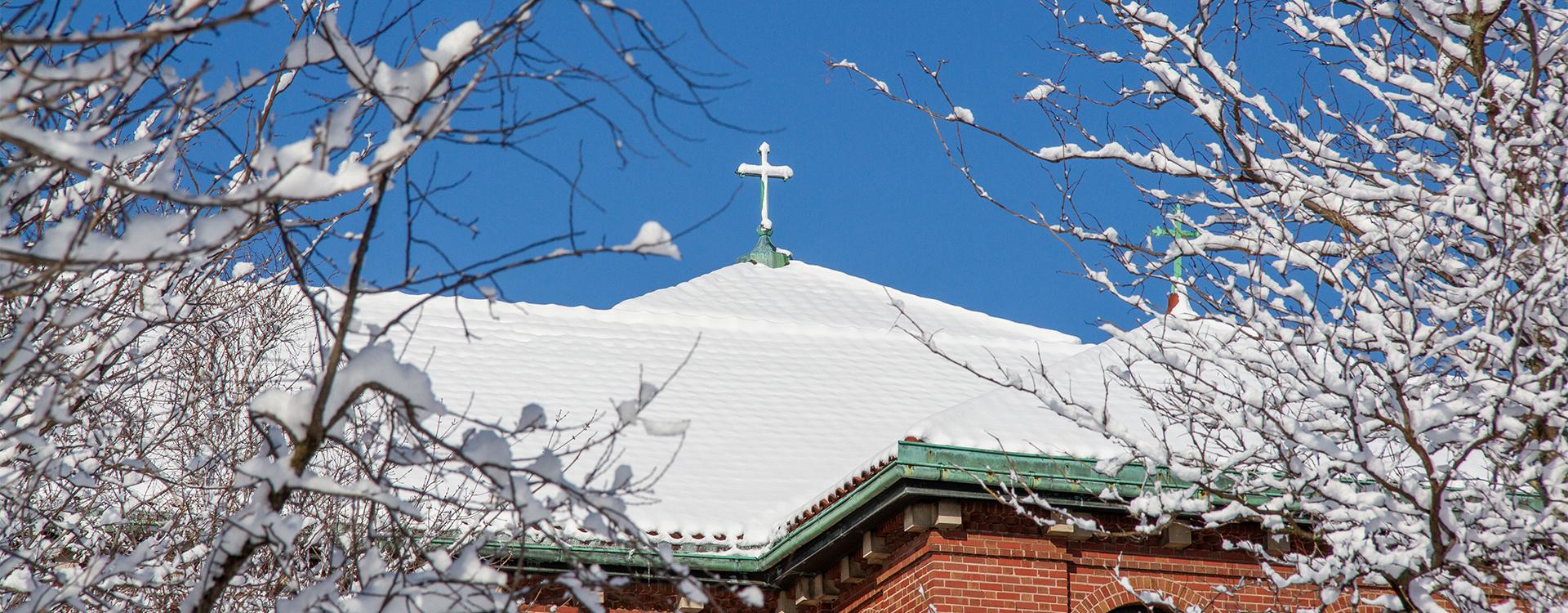 Snow on a rooftop cross